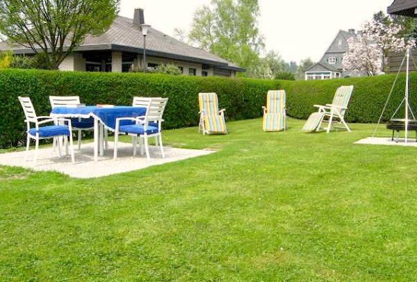 Große Liegewiese mit Sitzmöglichkeit hinter dem Haus