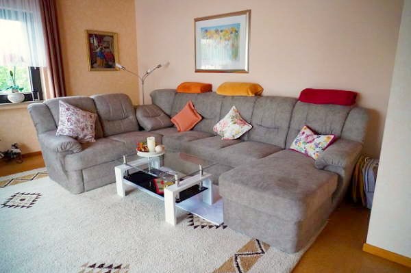 Wohnzimmer mit Sitzgruppe und Zugang zum Balkon